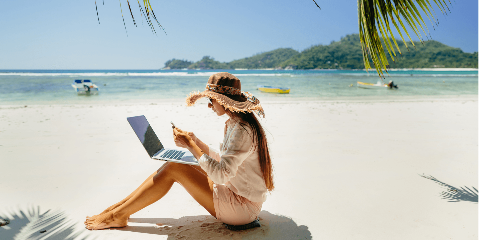 Person using a laptop and mobile phone while travelling