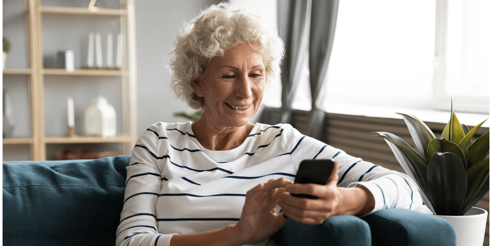 Older person smiling while using a mobile phone