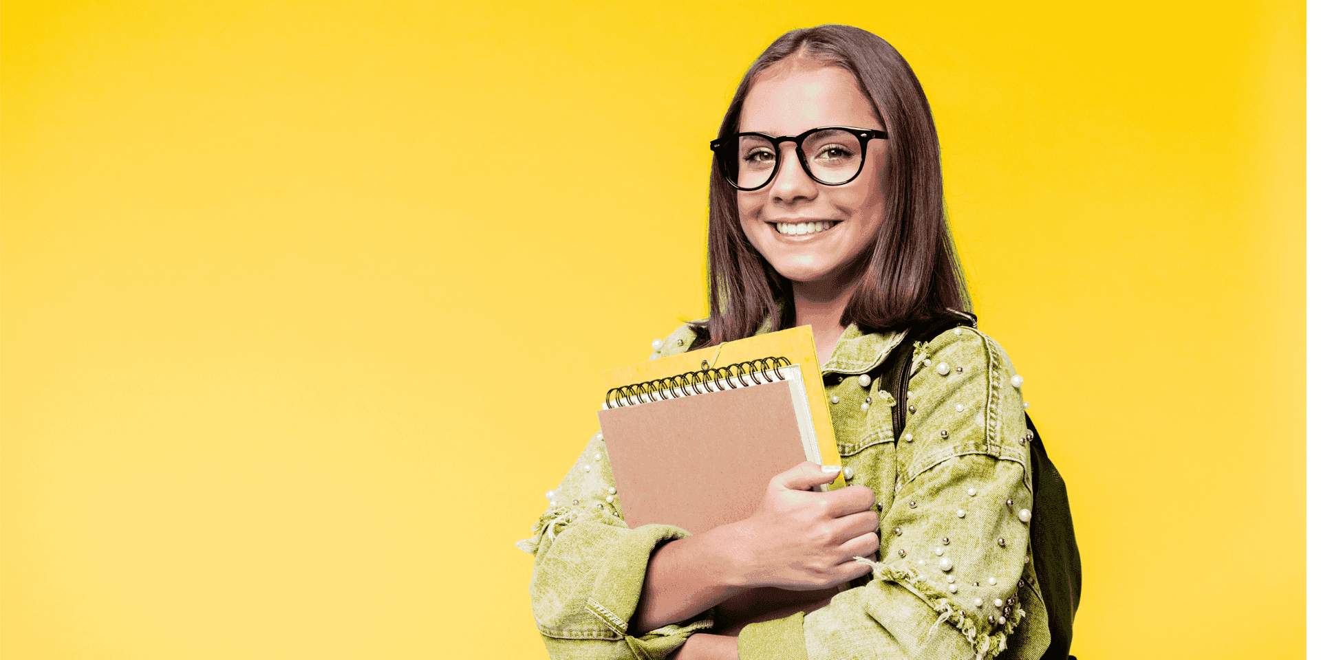 Smiling UK student carrying notebooks