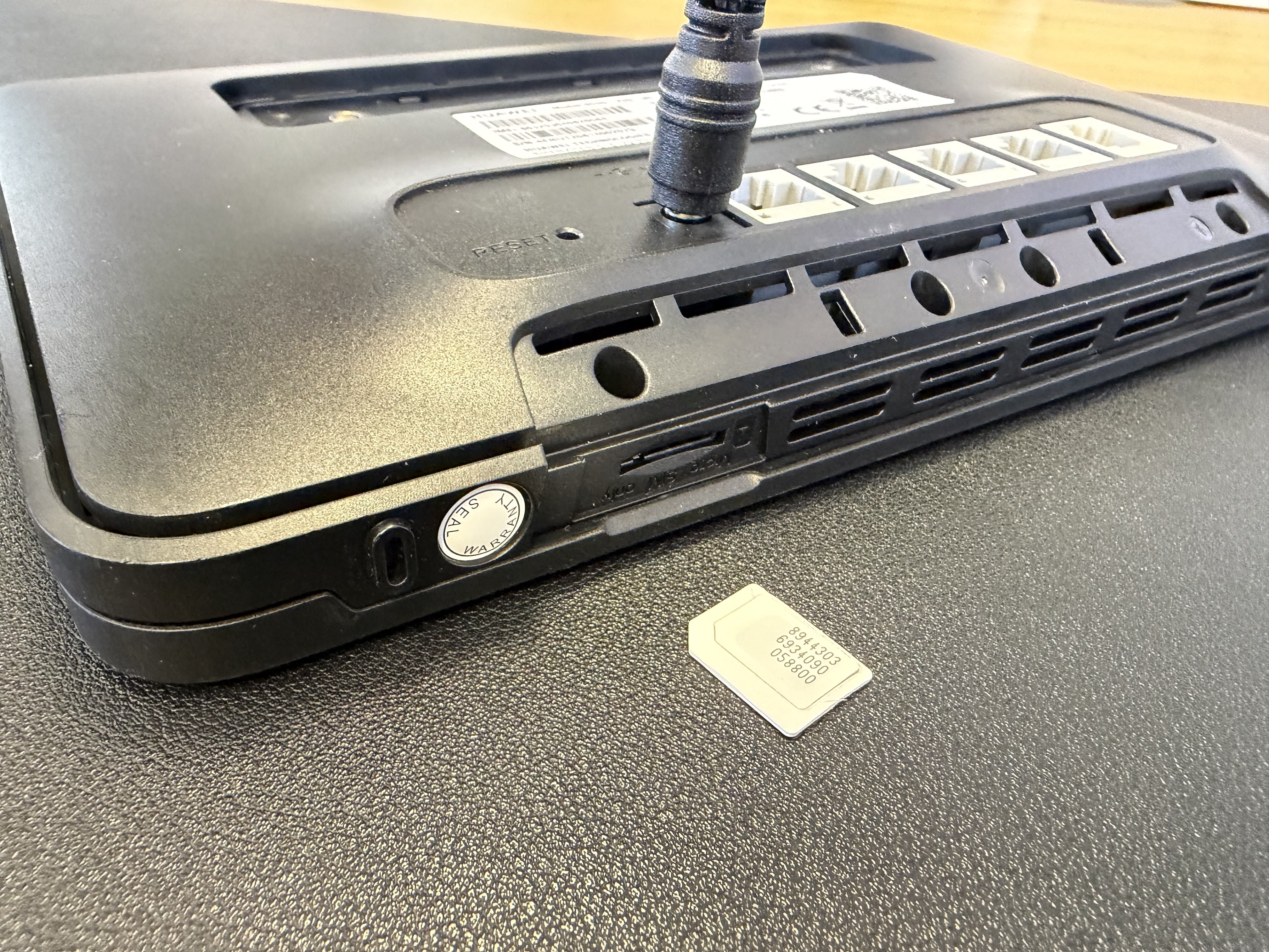 Side of the Huawei B535-235 with SIM slot open and SIM card placed alongside